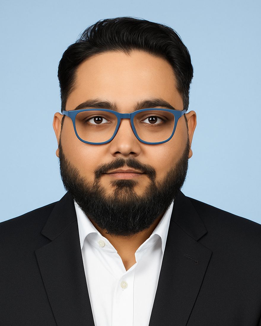 Portrait of Utsav Thakur in a dark suit and blue glasses